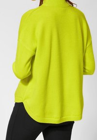 Limegrüner Pullover mit hohem Kragen, lässiger Passform und überschnittenen Schultern, mit strukturiertem Strick und abgerundetem Saum.