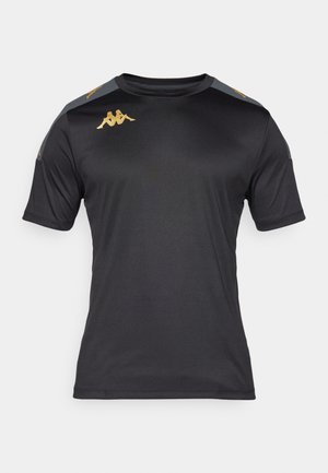 Camiseta deportiva negra de manga corta con paneles grises en los hombros y logotipos dorados de Kappa en el pecho y los hombros, mostrada sobre fondo blanco.