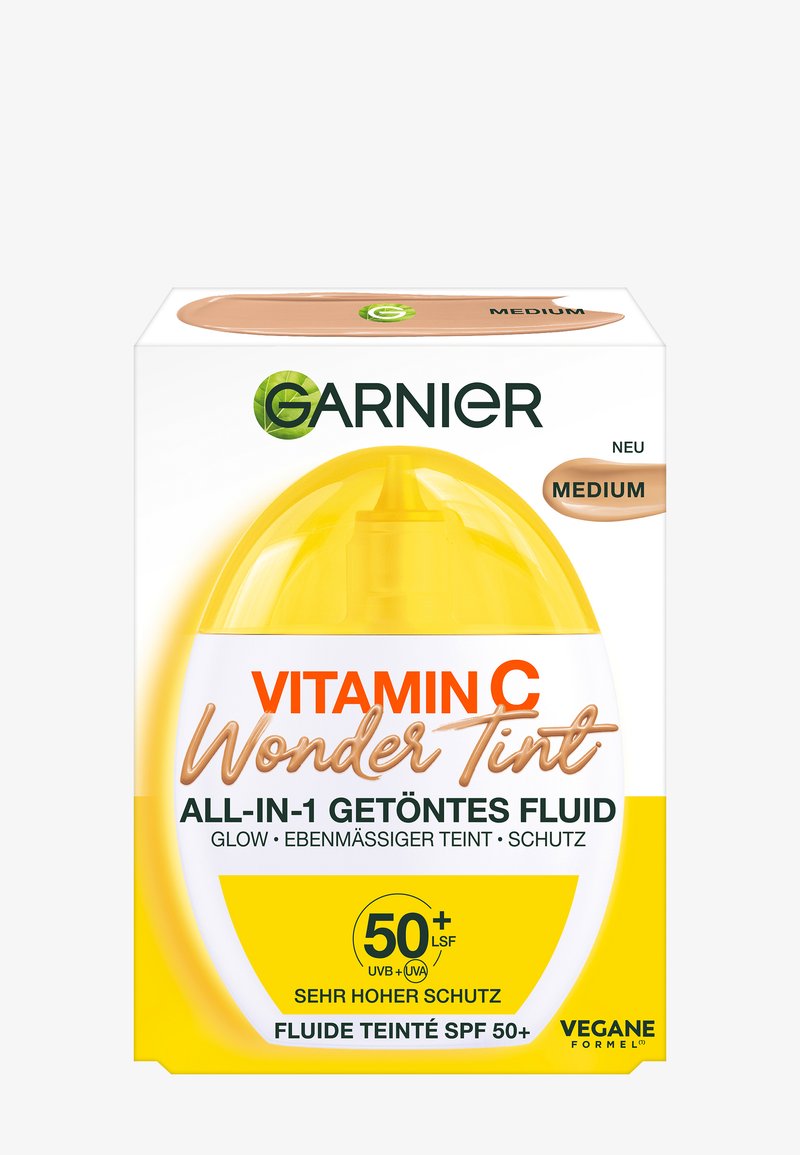 Verpakking van Garnier Vitamin C Wonder Tint, met een geel-wit ontwerp, een doorzichtige dop en bruine accenten, gelabeld als "Medium" en SPF 50+