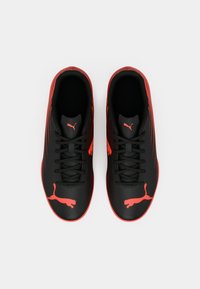 Mustat urheilukengät, joissa punaiset korostukset, sileä päällinen, perinteiset nauhat ja sivuilla näkyvä punainen Puma-logo.