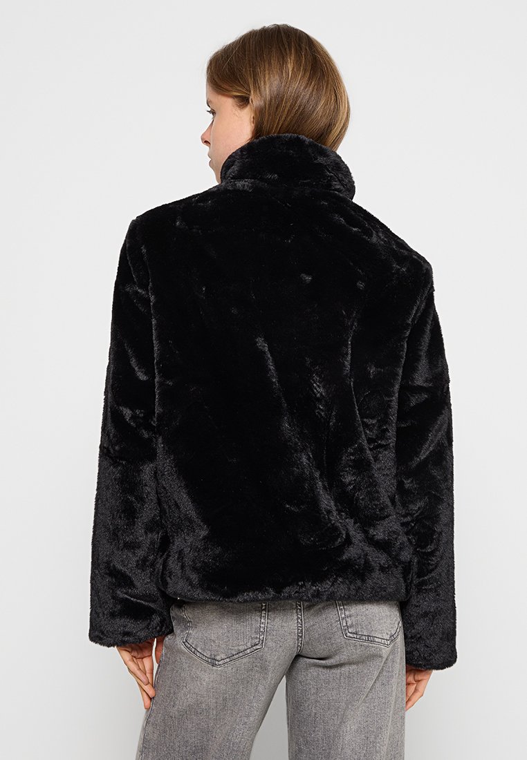 Schwarze Kunstfelljacke mit hohem Kragen, die eine weiche Textur und einen lässigen Schnitt aufweist. Die Ärmel sind gerade geschnitten, was den Komfort und die Wärme erhöht.