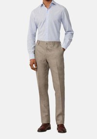 Light blue and white striped dress shirt paired with beige tailored trousers. Brown leather shoes complete the outfit. Smooth fabric texture.