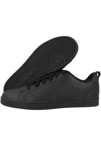 Sneakers in pelle nera con suola in gomma nera testurizzata, caratterizzati da accenti perforati, lacci piatti e un logo sul lato.