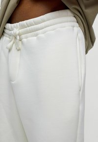Witte sweatpants met een zachte textuur, elastische tailleband, koordsluiting en zijzakken. Ontworpen voor comfort en casual dragen.