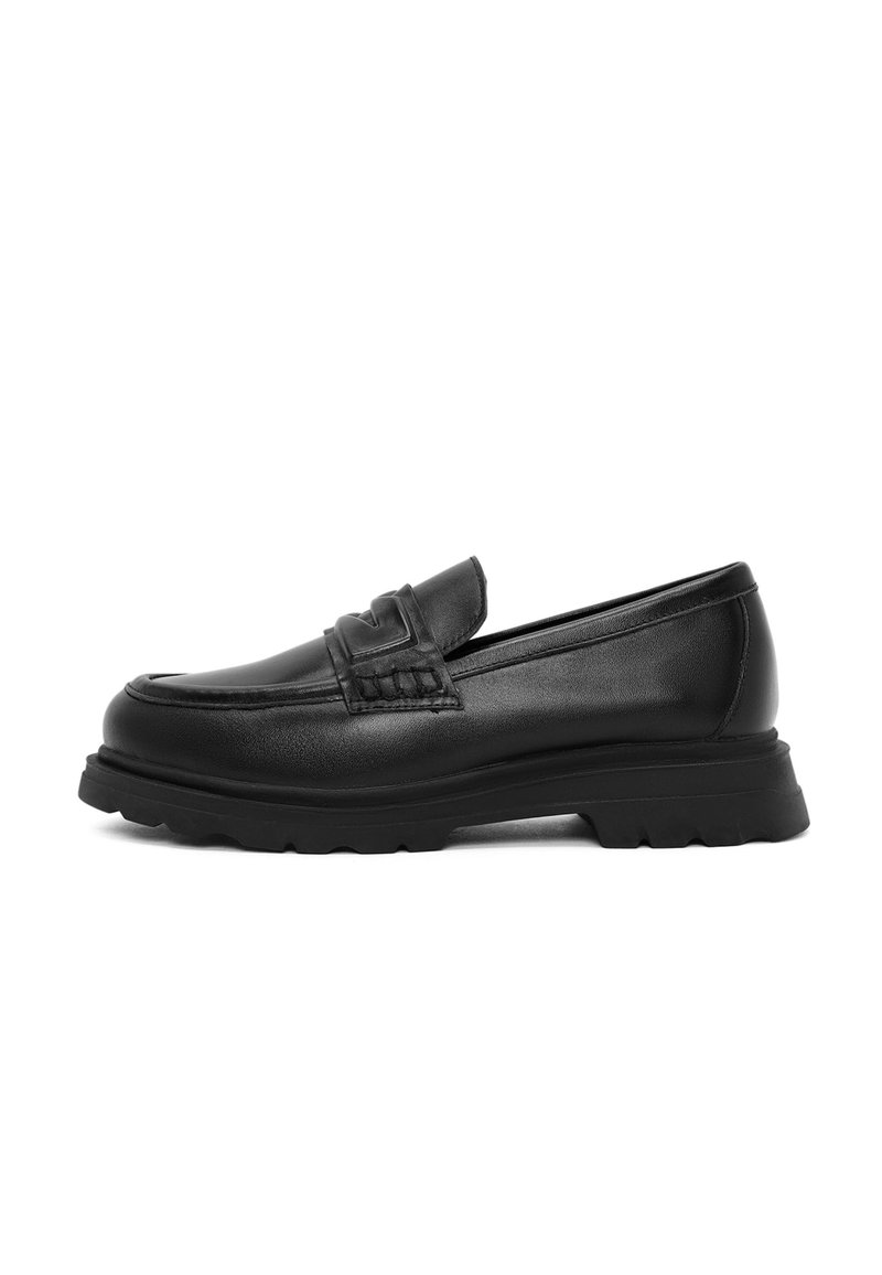 Mocassins en cuir noir avec un devant texturé, un col rembourré et une semelle en caoutchouc épaisse, présentant un design à profil bas et des détails de couture subtils.