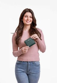 Green leather wallet with a zipper, rectangular shape, held by a person wearing a ribbed pink sweater against a white background.