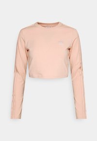 Pink cropped sweatshirt with long sleeves, made of soft fabric. Features three white stripes along each arm and a small logo on the chest.