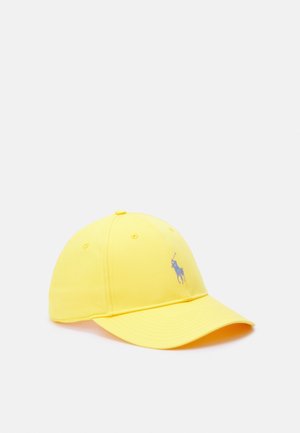 Żółta czapka bejsbolowa z niebieskim haftowanym logo gracza polo na przodzie, sześcioma otworami wentylacyjnymi i zakrzywionym daszkiem na jednolitym tle.