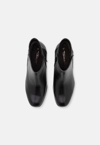 Botines de cuero negro con una superficie lisa, puntera afilada y acentos textiles decorativos. Talla 37 marcada en el interior.