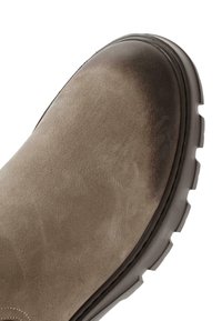 Bottine cheville en suède beige avec un bout arrondi, une surface texturée et une semelle en caoutchouc épaisse présentant un motif de traction.