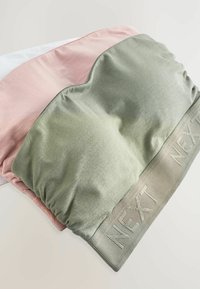Draadloze crop top in groen, roze en witte stof. Zachte, rekbare materie met een gemêleerde band waarin "NEXT" is gedrukt.