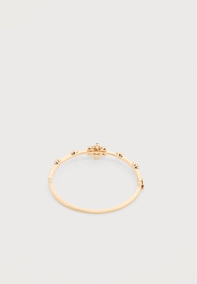 Βραχιόλι σε χρυσό χρώμα με μικρά στρογγυλεμένα διακοσμητικά καρφιά τοποθετημένα ομοιόμορφα γύρω από τη ζώνη σε λευκό φόντο.