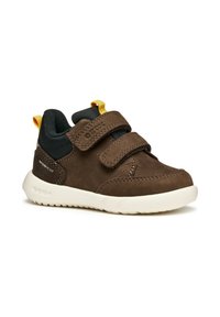Chaussures en suède marron pour tout-petits avec des accents en mesh noir, deux bandes Velcro et une semelle en caoutchouc blanc. Comprend une languette jaune au talon.