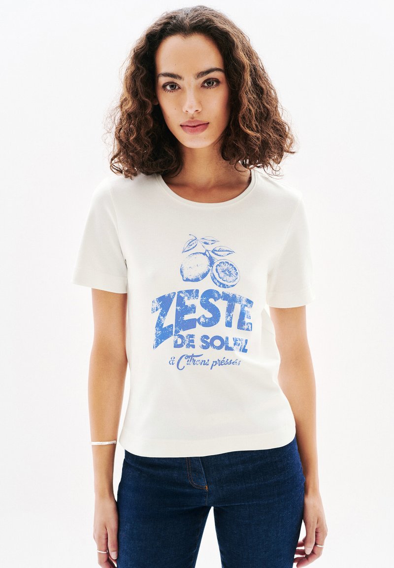 Vit bomull t-shirt med blå grafisk tryck av citrusfrukter och texten "ZESTE DE SOLEIL". Korta ärmar med rund halsringning.