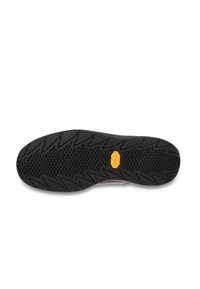 Semelle en caoutchouc noir avec un motif de semelle distinctif et un logo jaune. Transition fluide entre la semelle et l'empeigne, avec un design texturé.