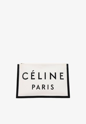 Bílá obdélníková taštička na zip s černým lemováním, na přední straně výrazný nápis "CÉLINE PARIS" v tlustých černých písmenech.