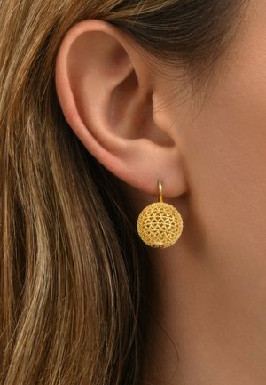 Boucles d'oreilles en or, sphériques, avec un motif délicat en dentelle, présentant une surface texturée et un petit anneau pour l'attache.