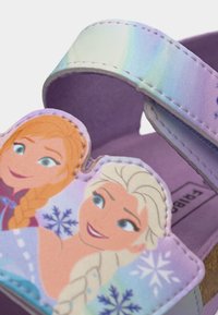 Παιδικό μοβ σανδάλι με ρυθμιζόμενο λουράκι, διακοσμημένο με καρτούν πρόσωπα δύο κοριτσιών και σχέδια με νιφάδες χιονιού.