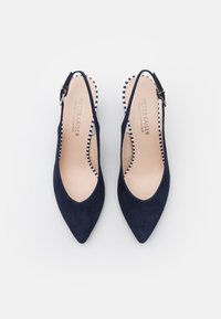 Décolleté slingback in camoscio blu navy con punta a punta, dotate di una soletta a quadri e una piccola cinturino con fibbia. Design classico ed elegante.