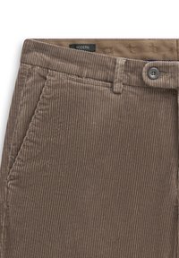 Gros plan sur un pantalon en velours côtelé marron avec poche avant, fermeture par bouton, passants pour ceinture et ceinture intérieure étiquetée Modern.