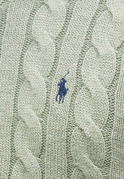 Ανοιχτό πράσινο πλεκτό ύφασμα με παχιά καλωδιωτά σχέδια και ένα μικρό κεντητό λογότυπο με καστανό άλογο και αναβάτη στο κέντρο.