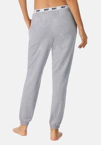 Grijze joggingbroeken met een elastische tailleband met het DKNY-logo, met een gecuffeerde enkel en van zacht katoen, gezien vanaf de achterkant.