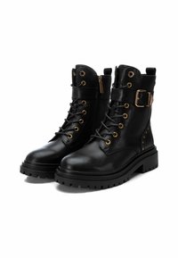 Botas de combate de cuero negro con ojales dorados y detalles de hebilla, que cuentan con un acabado texturizado, cordones en la parte delantera y una suela resistente.