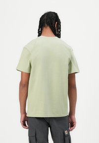 Light green short-sleeve t-shirt with a comfortable fit, round neckline, and smooth texture, viewed from the back.
