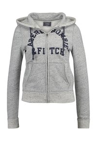 Felpa grigia con zip realizzata in tessuto morbido. Presenta un cappuccio, due tasche anteriori e testo navy con la scritta "Abercrombie & Fitch" sul petto.