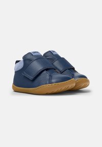 Granatowe skórzane buty z rzepami, brązowa gumowa podeszwa, zaokrąglony czubek i miękkie zamszowe akcenty na cholewce. Wygodny, casualowy design.