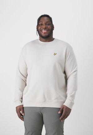 Light beige sweatshirt with crew neck, ribbed cuffs, and hem; features a small yellow embroidered logo on the chest.
