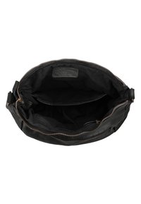 Black leather handbag open to show interior with fabric lining, a main compartment, a zippered pocket, and a slip pocket inside.