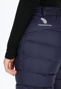 Pantaloni puffer blu navy con motivo trapuntato, dotati di cerniera laterale e logo "PREMIUM DOWN". Tessuto morbido e isolato per calore.