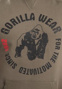 Grijze hoodie met een zwart gorilla-graphic en de tekst "GORILLA WEAR FOR THE MUTILATED SINCE 1982" en een rode accent. Van katoen.