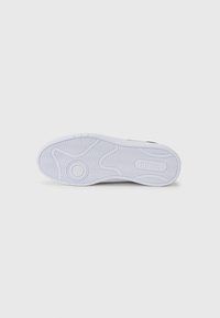 Semelle de sneaker en caoutchouc blanc présentant un motif de grip texturé et un logo embossé. Fini lisse avec des contours pour la traction et le soutien.