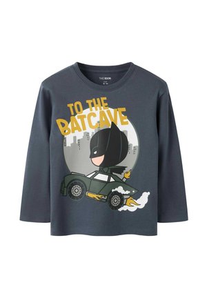 T-shirt à manches longues gris foncé avec un Batman dessin animé conduisant une voiture et le texte "TO THE BATCAVE" au-dessus de la silhouette de la ville.