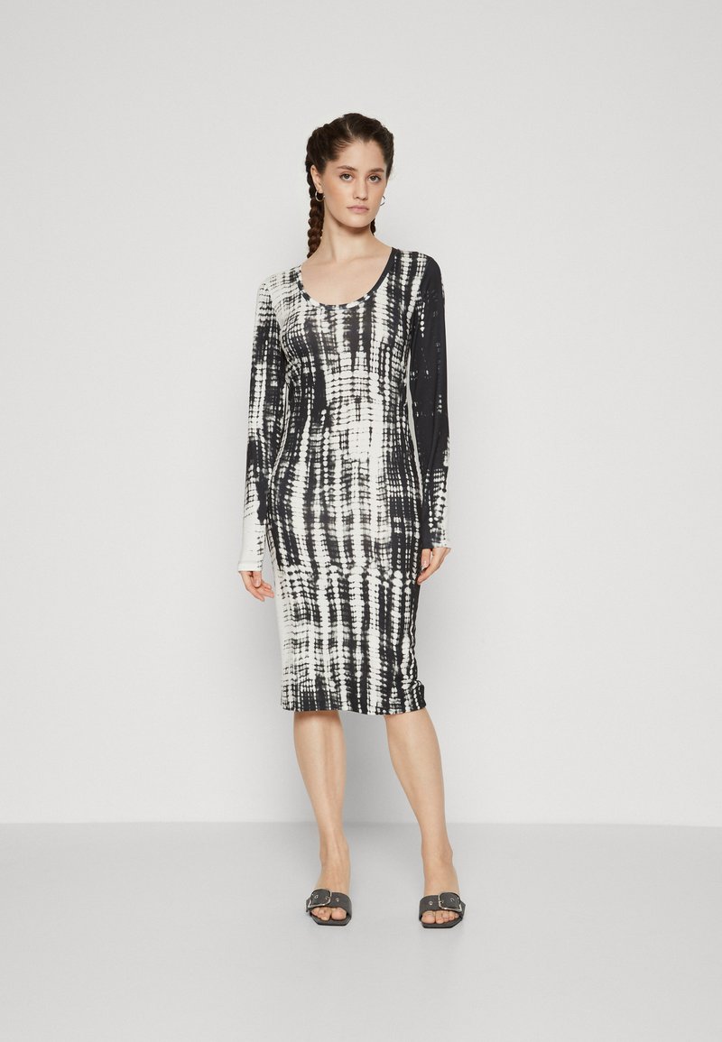 Long-sleeve dress in black and white tie-dye pattern, fitted design, scoop neckline, mid-calf length, fabric appears smooth and stretchy.