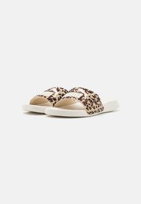 Sandales à glissière avec motif léopard, offrant une texture douce, une conception à large bride et une semelle blanche rembourrée. Les brides présentent un motif à rayures.