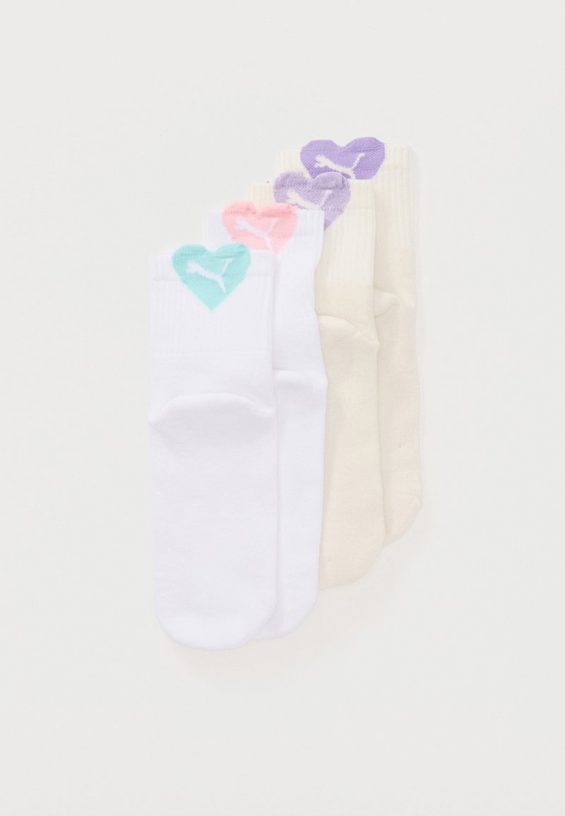 Zwei Paare weiße Socken und zwei Paare beige Socken, jeweils mit einem farbigen Herz und Puma-Logo am Bündchen.