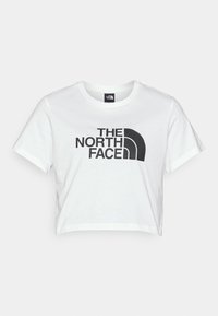 Bijela skraćena majica od pamuka s velikim crnim logom "THE NORTH FACE" i ikoničnom grafikom polu-dome na prednjoj strani.