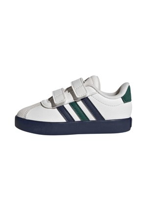 Weißer Sneaker mit marineblauer Sohle, zwei Klettverschlüssen und grünen sowie marineblauen Streifen an der Seite, von der Außenseite gezeigt.