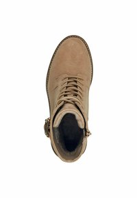 Bottine en suedine beige, avec lacets, bout rond et doublure en fausse fourrure. Elle présente une fermeture éclair sur le côté et un accent en matériel décoratif.