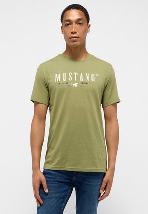 Olivově zelené tričko s krátkým rukávem s bílým nápisem a logem "MUSTANG" vytištěným na přední straně. Měkká textura, standardní střih, design s kulatým výstřihem.