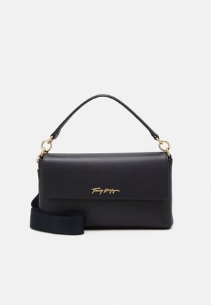 Sac à main rectangulaire noir avec rabat, logo doré, poignée courte et bandoulière longue amovible sur fond blanc.