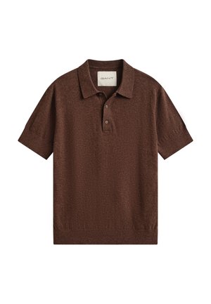 Pruun lühikeste varrukatega kootud polo särk krae ja kahe nööpidega plakeeringuga, soonikkoes mansettide ja alumise äärega ning valge "GANT" sildiga krae sees.