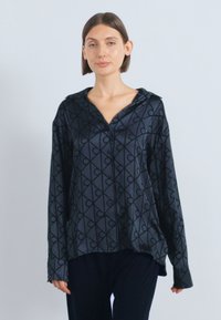 Cămașă neagră cu nasturi și model geometric în gri închis, cu guler mare, confecționată dintr-un material neted, cu croială lejeră.