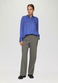 Blauwe satijnen button-up shirt met een kraag, gecombineerd met lichtgrijze op maat gemaakte broek en zwarte platform schoenen, met een gladde textuur.
