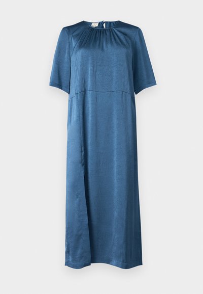 Kék, rövid ujjú ruha sima, enyhén gyűrött anyagból; kerek kivágással és kulcslyuk záródással a hátsó részen.