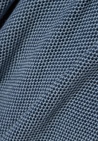 Woven fabric o fakturze w kolorze średnim niebieskim, z wzorem siatki i wypukłymi ściegami, wykazującym miękką, elastyczną teksturę.