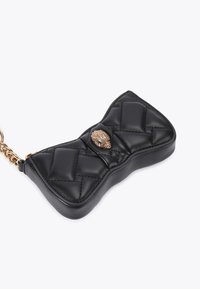 Clutch in pelle nera trapuntata con una forma unica a fiocco, caratterizzata da una chiusura decorativa oro al centro e una tracolla a catena.